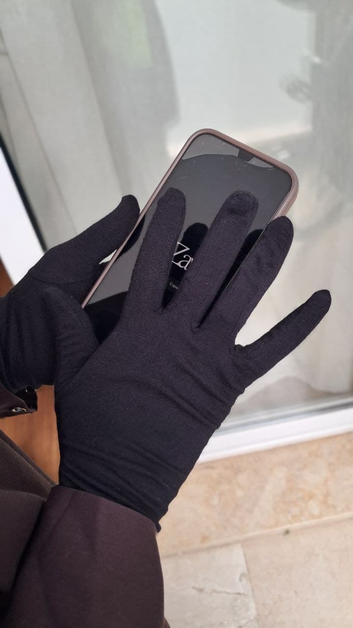 Gant tactile noir Az Zawja utilisé sur l'écran d'un téléphone